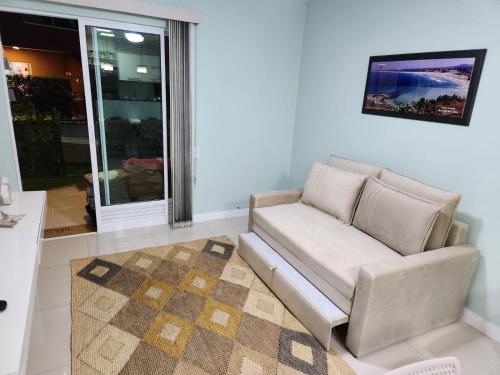 sala de estar con sofá y alfombra en Golden Lake Residence Arraial do Cabo, en Arraial do Cabo