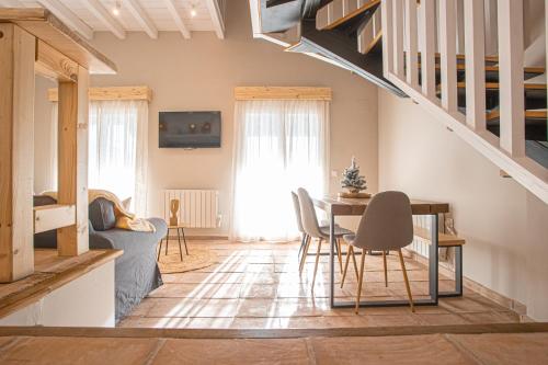 a living room with a table and chairs and stairs at ALYA junto a CARD in Sierra Nevada