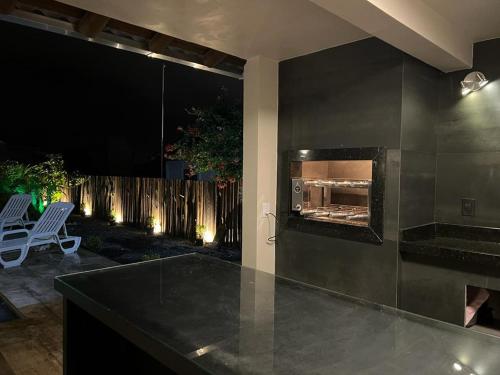 a kitchen with a fireplace and a patio at night at Residencial Manauara Torres in Torres