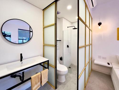 W łazience znajduje się umywalka, toaleta i lustro. w obiekcie OASIS TROPICAL HOTEL w mieście Santa Marta