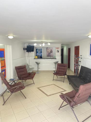 リオアチャにあるHotel La Guajiraの椅子とテレビが備わる待合室