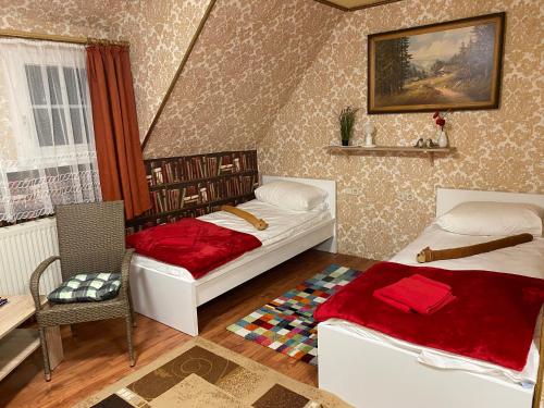 um quarto com 2 camas, uma mesa e uma cadeira em Haus ZUR PINGE em Kurort Altenberg