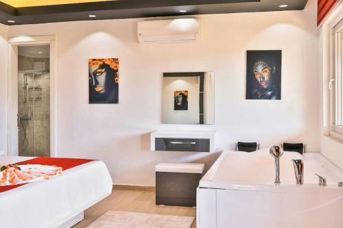 a bathroom with a white tub and a sink at Villa Çalıkuşu Kalkan in Kaş