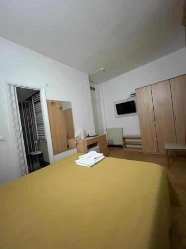 a large room with a yellow bed and cabinets at Hotel Villa Costa in Celle Ligure