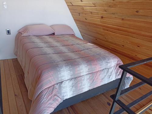 a bed in a room with a wooden wall at NOPALLIMAGUEY in Mexico City