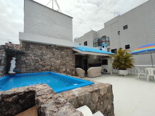 uma piscina em frente a um edifício em Cobertura Enseada Guarujá - 250 metros da praia no Guarujá
