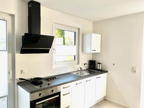 a white kitchen with a sink and a stove at Ferienwohnung Brochenzell - nahe Ravensburger Spieleland in Meckenbeuren