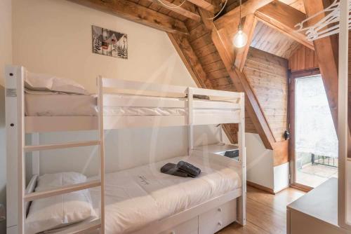 a bedroom with bunk beds in a wooden house at Casa Montjòia by SeaMount Rentals in Las Bordas