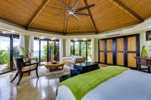 een slaapkamer met een groot bed en een plafondventilator bij PUNTA GABRIELA in Dominical