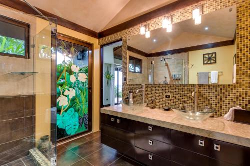 een badkamer met 2 wastafels en een glazen douche bij PUNTA GABRIELA in Dominical