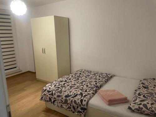 a small bedroom with a bed and a cabinet at Apartament Cluj in Floreşti