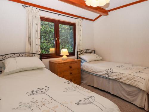 Duas camas num quarto com uma janela em Dartmoor Retreat Lodge em Exeter