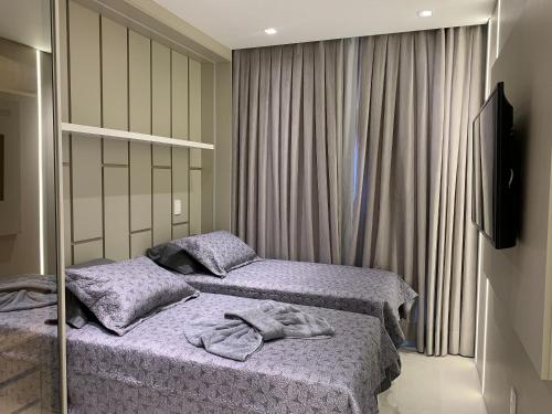 1 dormitorio con 2 camas y toallas. en Residencial Waldgarten Bombinhas en Bombinhas