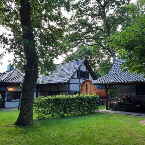 a house with a tree in the yard at Heuerhaus Gut Einhaus in Werlte