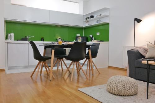 a kitchen with a table and chairs in a living room at Apartman Čakovec in Čakovec