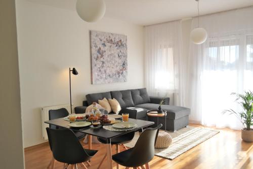 uma sala de estar com um sofá, uma mesa e cadeiras em Apartman Čakovec em Čakovec