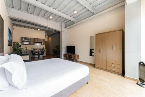 une chambre avec un grand lit blanc et un salon dans l'établissement Signature by VH Lofts & apartments Roma Norte, à Mexico