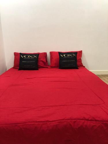 a red bed with two black pillows on it at Penang 5bedroom Bungalow with pool in Batu Ferringhi
