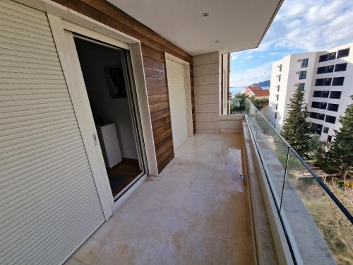 AS Apartments Rafailovici في رفايلوفيتشي: شرفة منزل مع باب مفتوح