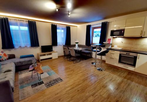 a living room with a couch and a table and a kitchen at Haus Dirol in Kirchberg in Tirol