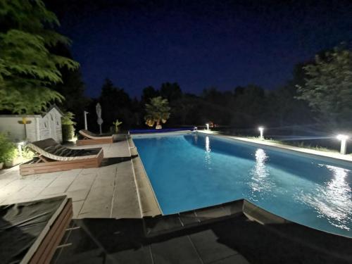 - une grande piscine éclairée la nuit dans l'établissement Grande maison familiale 12p à proximité de Blois, à Cellettes