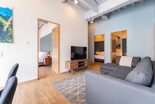 a living room with a couch and a tv at Roma Norte Apartments by VH in Mexico City