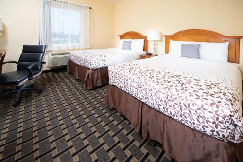 a hotel room with two beds and a chair at Mt. Rose Hotel in Fayetteville