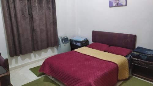 1 dormitorio con 1 cama con manta roja y amarilla en Studio Au Centre Ville Prés de la Medina, en Fez