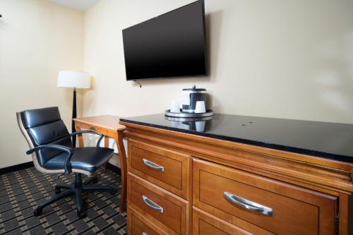 a hotel room with a desk with a television and a chair at Mt. Rose Hotel in Fayetteville