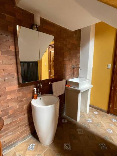 a bathroom with a tub and a sink and a mirror at VILLAS MARCO POLO in Panajachel