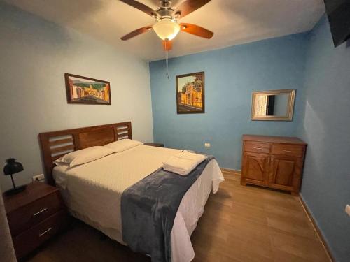 a bedroom with a bed and a ceiling fan at VILLAS MARCO POLO in Panajachel