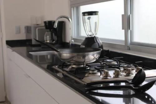 a kitchen stove with a pan on top of it at Papaya Condo Acapulco Diamante -Solo Adultos in Acapulco