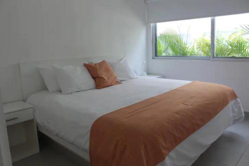 1 dormitorio con 1 cama grande y ventana en Papaya Condo Acapulco Diamante -Solo Adultos, en Acapulco