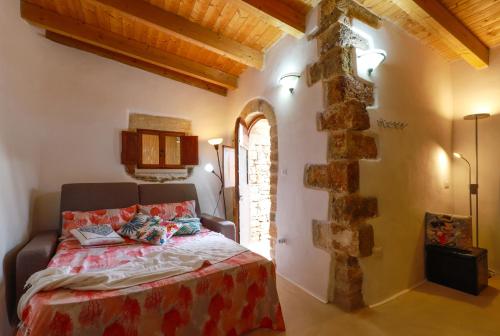una camera con un letto in una stanza con un muro in pietra di Affascinante Grande Liama Antica a Salve