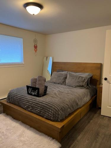 een slaapkamer met een groot bed met een houten hoofdeinde bij *NEWLY RENOVATED* COZY 2 BDRM ENTIRE APT in Tacoma