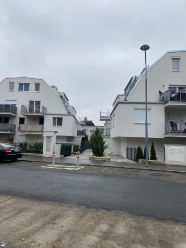 Une rangée d'immeubles d'appartements blancs dans une rue dans l'établissement Modern apartment with garden near city center, à Vienne