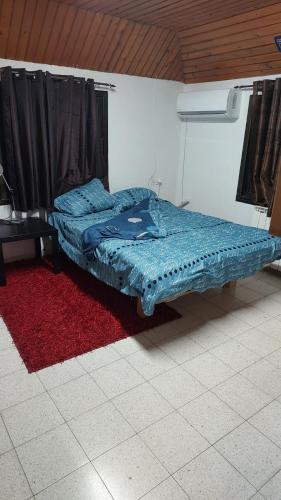un letto in una camera con tappeto rosso di אצל תיקי במושב a Sha'al