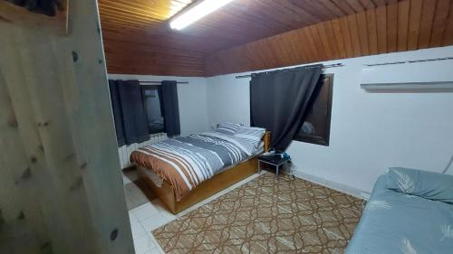 una piccola camera con letto e finestra di אצל תיקי במושב a Sha'al