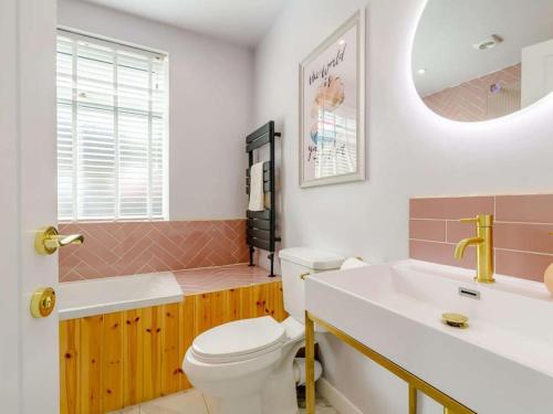 a bathroom with a toilet and a sink and a mirror at Dawns House Cromford The Peaks in Cromford