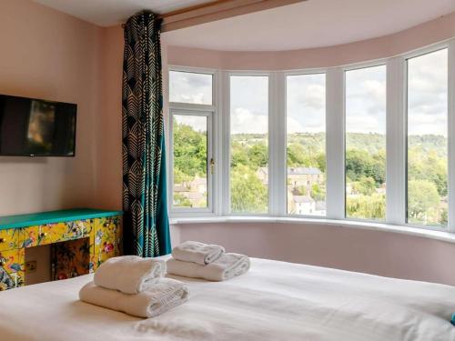 a bedroom with a large bed with towels on it at Dawns House Cromford, Peak District, Hot Tub, for 6 - stunning views in Cromford