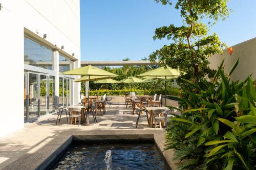 a patio with tables and chairs and a pool of water at Hotel Mio Vallarta - Adults Only in Puerto Vallarta