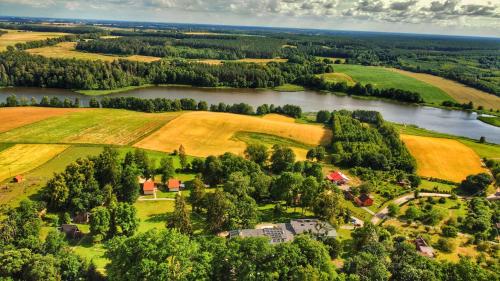 an aerial view of a farm next to a river at Folwark Wierzchy in Wierzchy