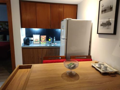 a kitchen with a wooden table with a refrigerator at Bonaparte: flat com suíte, vista incrível e WI-FI in Brasilia