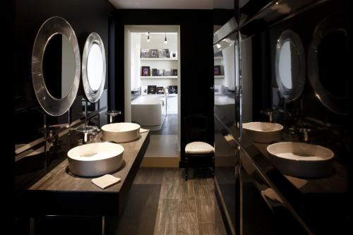 a bathroom with four sinks and two mirrors at Auberge Du Paradis in Saint-Amour-Bellevue