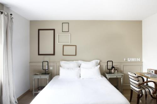 a bedroom with a white bed and two chairs at Auberge Du Paradis in Saint-Amour-Bellevue