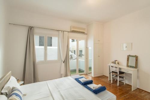 um quarto com uma cama, uma secretária e uma janela em Traditional Home em Naousa