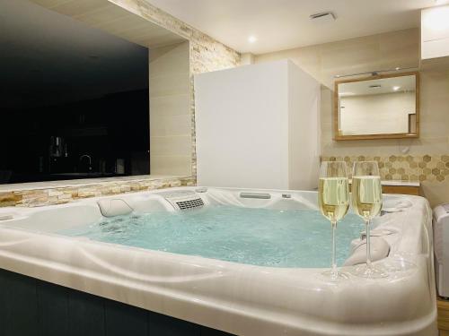 a bath tub with two wine glasses in it at Un moment hors du temps - Jacuzzi - Sauna - Billard -Baby-Foot- Parking - 167 in Rouen