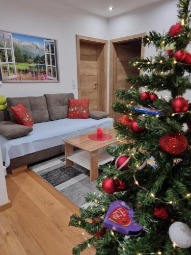 a living room with a christmas tree and a couch at Golf & Ski Appartements Mittersill Trausmuth Monika inkl Sommercard - Golfplatz 500 m entfernt, inkl Waschmaschine, Trockner in Mittersill