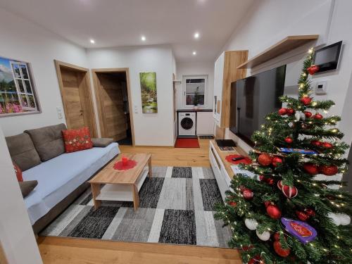 a living room with a christmas tree in the living room at Golf & Ski Appartements Mittersill Trausmuth Monika inkl Sommercard - Golfplatz 500 m entfernt, inkl Waschmaschine, Trockner in Mittersill