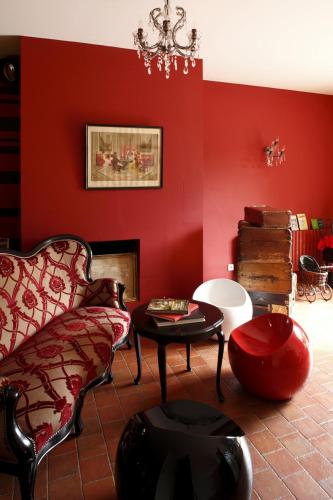 a red living room with a couch and a table at Auberge Du Paradis in Saint-Amour-Bellevue